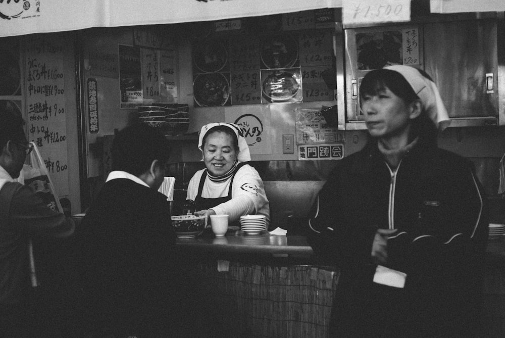 woman in black blazer sitting beside woman in white and black stripe shirt