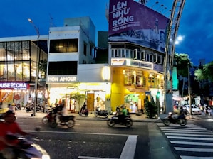 A brightly lit Banner Biker riding through a bustling city street at dusk, colorful banners catching every eye.