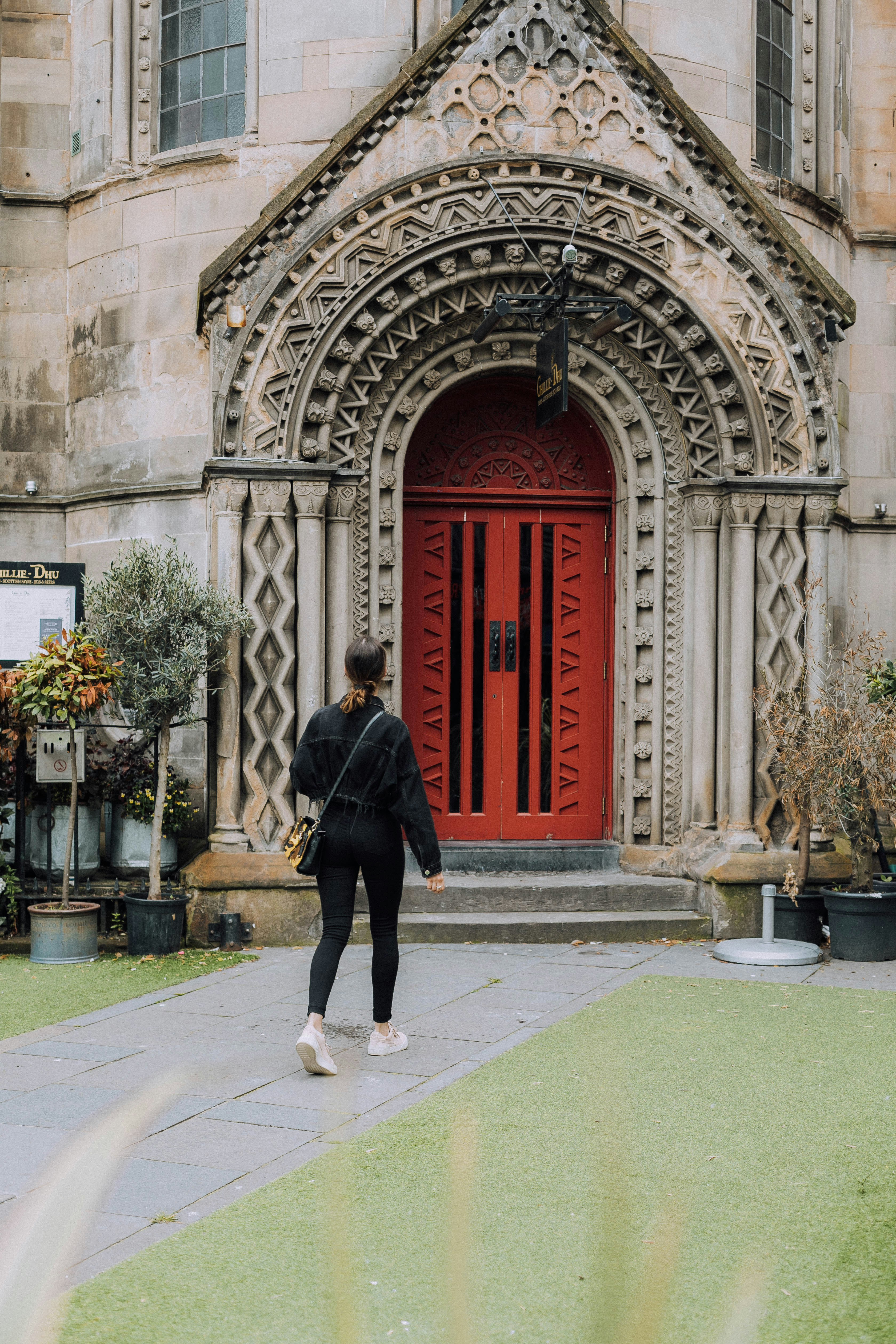 man in black coat walking on sidewalk during daytime