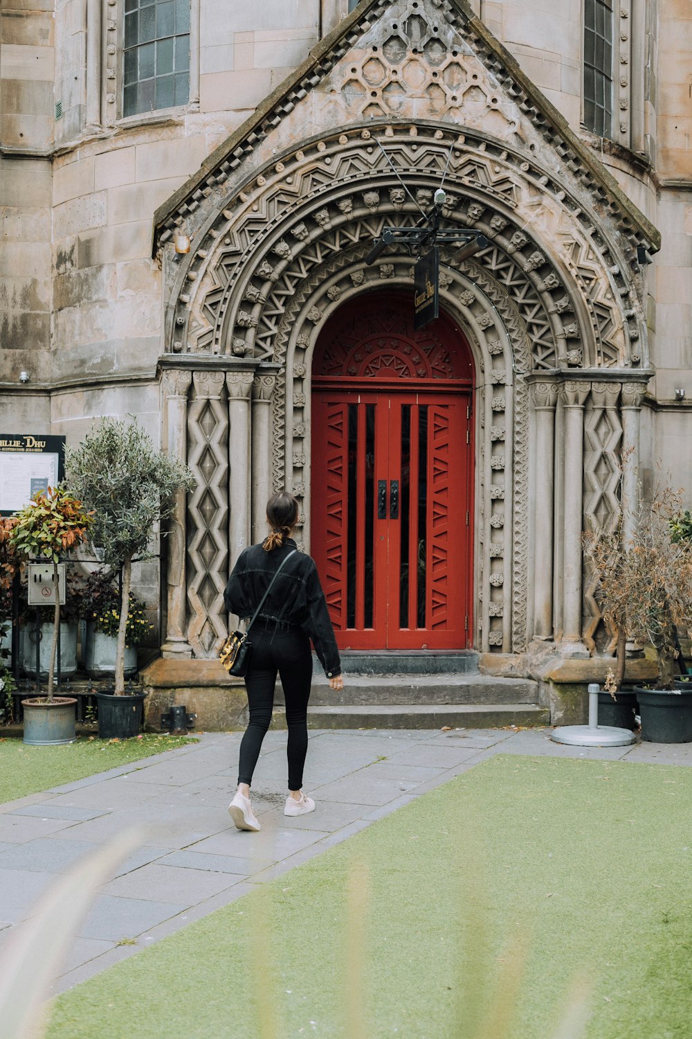 man in black coat walking on sidewalk during daytime