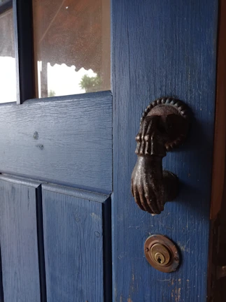 Close-up of a freshly painted vintage wooden door in deep blue with intricate brush strokes.