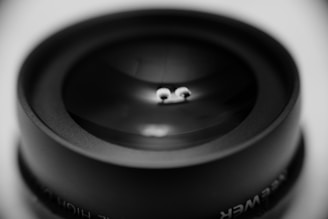 A close-up shot of a camera lens reflecting a colorful anime character.