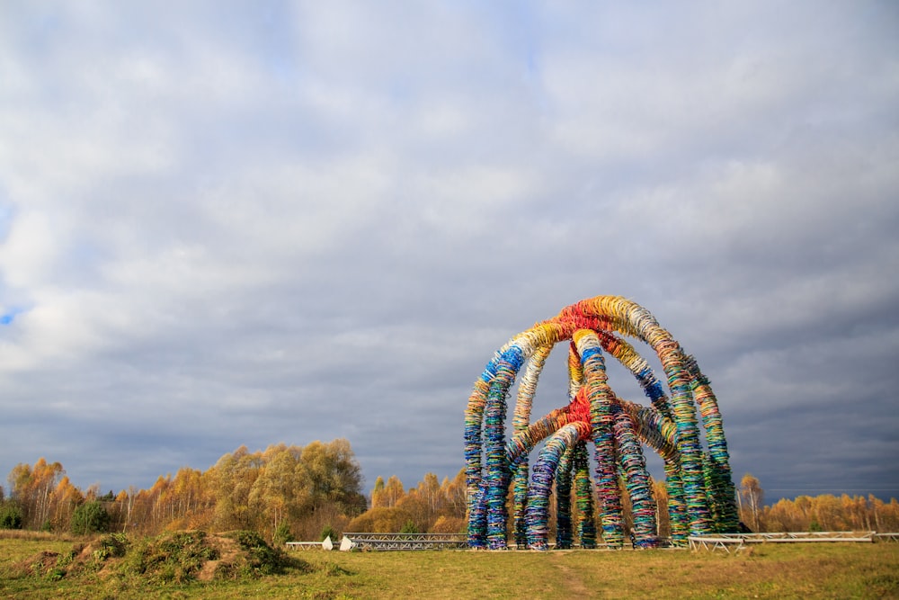 blue and yellow round structure on green grass field under gray cloudy sky