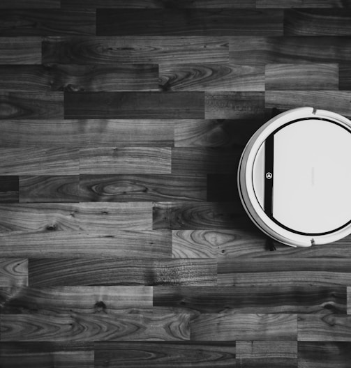 grayscale photo of round frame on wooden floor