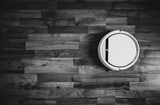 grayscale photo of round frame on wooden floor