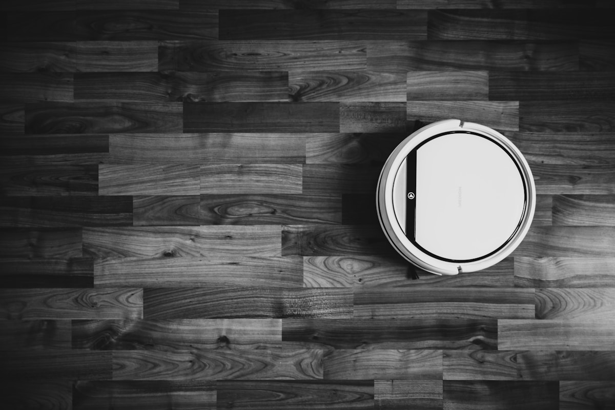 Grayscale photo of round frame on wooden floor