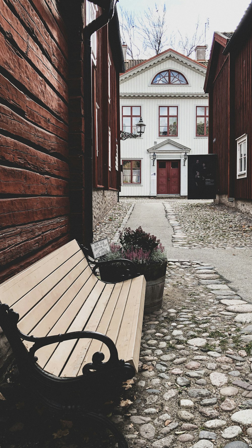 brown wooden bench beside red brick wall