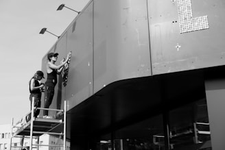 Photo of skilled workers applying exterior resin coating on a building wall.