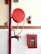 A red fire hose reel mounted on a wall alongside a fire extinguisher. The setup includes a red fire hose cabinet with a fire hose coiled inside, marked with the word 'FIRE' on the glass panel. The wall is tiled in white, contrasting with the red safety equipment.