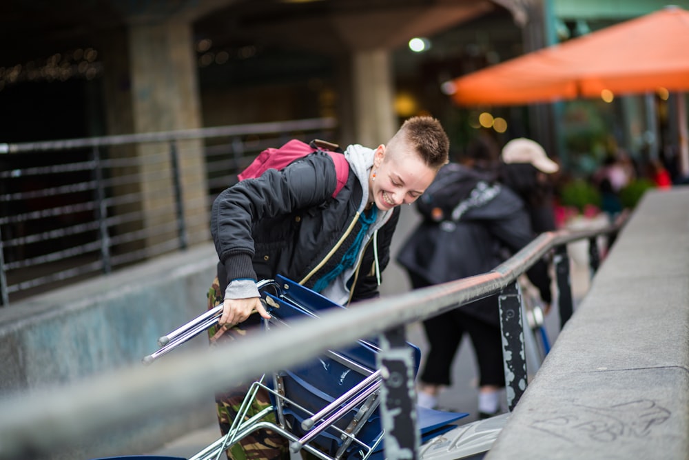 man in black jacket and blue denim jeans standing on train rail during daytime