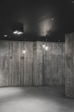 Interior shot of an urban loft with exposed concrete walls and warm gold lighting accents.