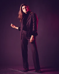 Artistic shot of a male model in a sharp black suit, exuding confidence with a hint of mystery.