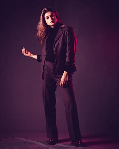 Artistic shot of a male model in a sharp black suit, exuding confidence with a hint of mystery.