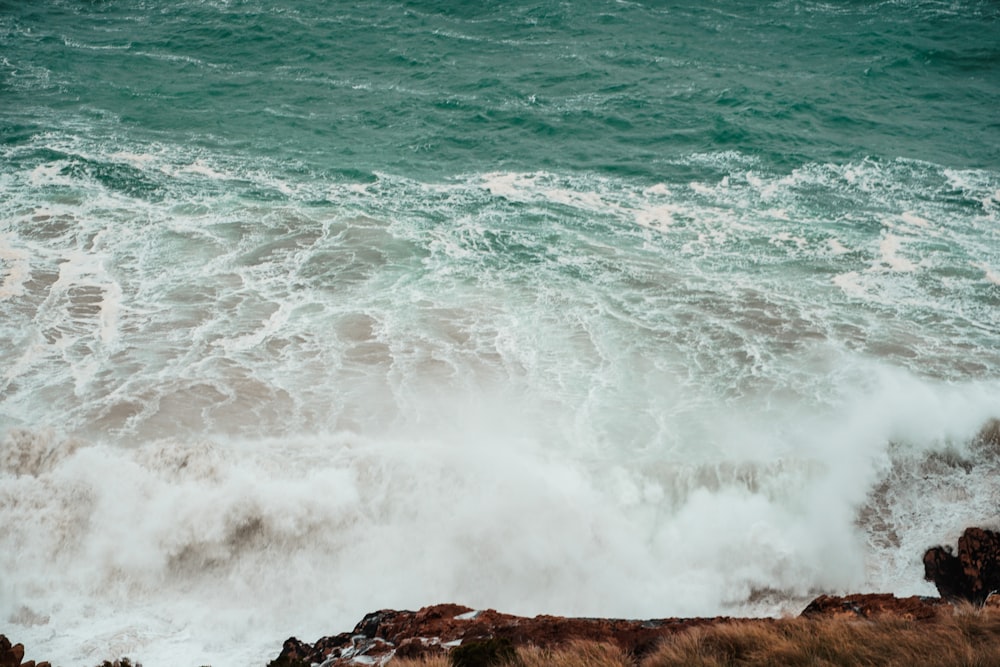 ocean waves crashing on brown rock