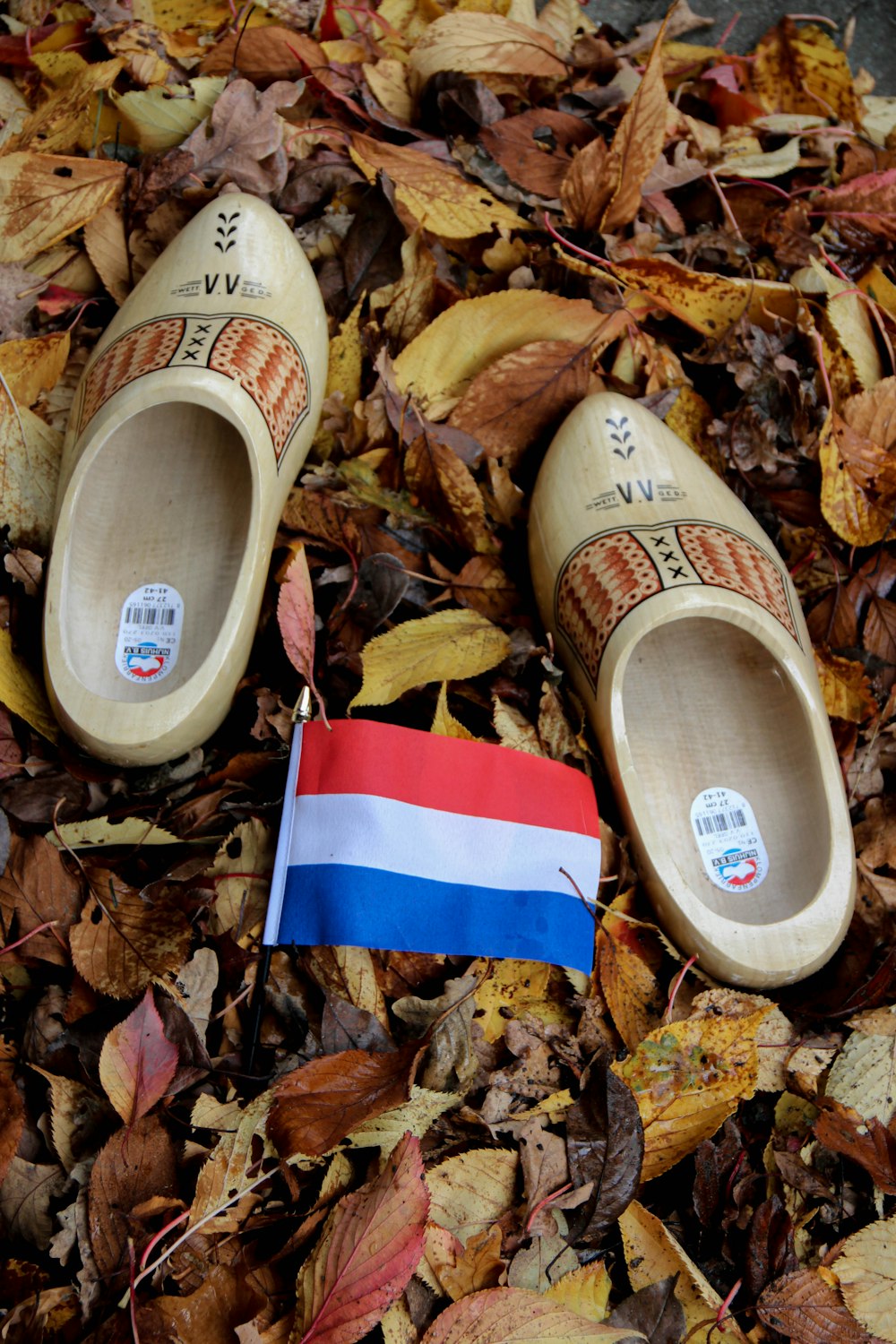 white red and blue striped slide sandal on dried leaves