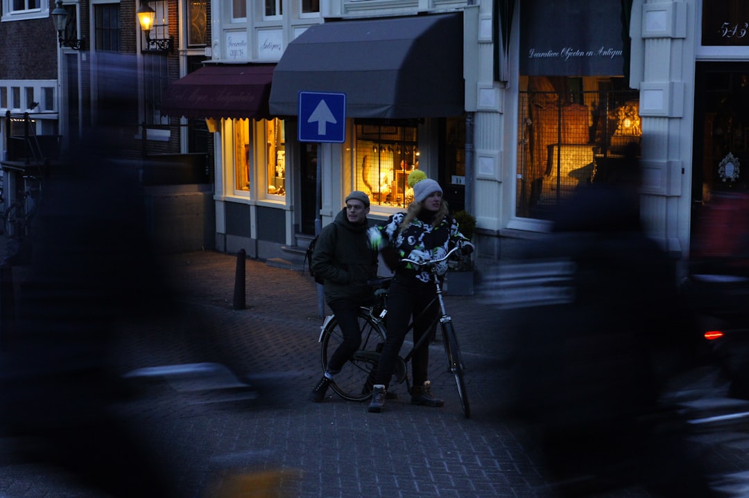 man in black jacket riding bicycle on road during night time