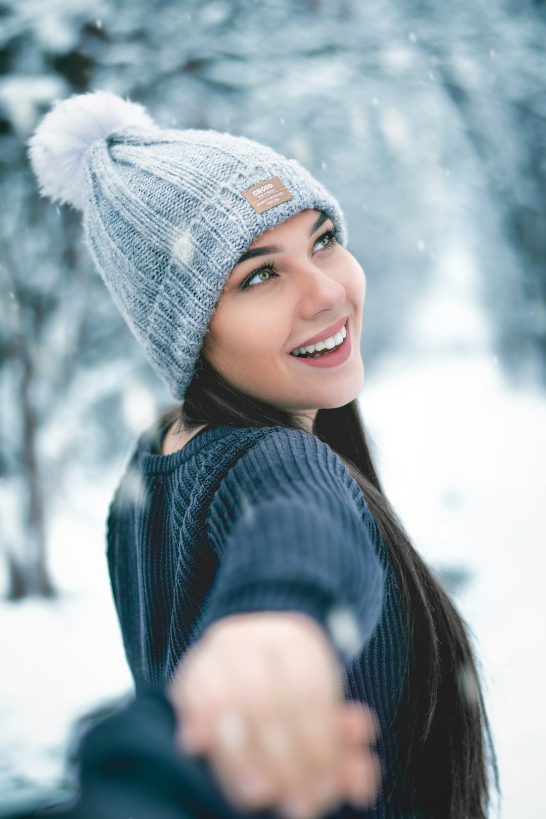 woman in blue knit cap and blue knit sweater smiling