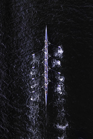 A rowing club using a large screen displaying boat GPS positions on a map during practice.