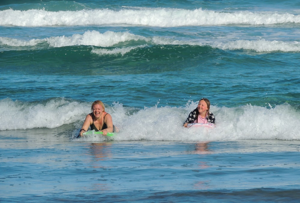 2 women in green bikini swimming on beach during daytime
