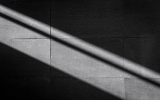 A medium square tile showing abstract shadows and light interplay in monochrome.