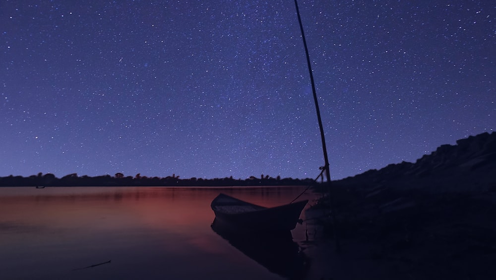 silhouette of mountain and body of water during night time