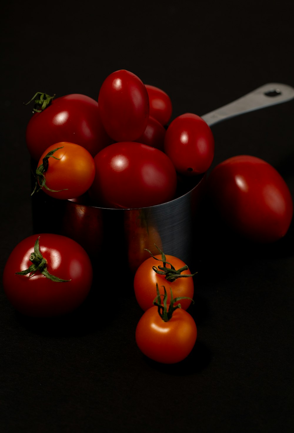 red tomatoes on stainless steel bucket