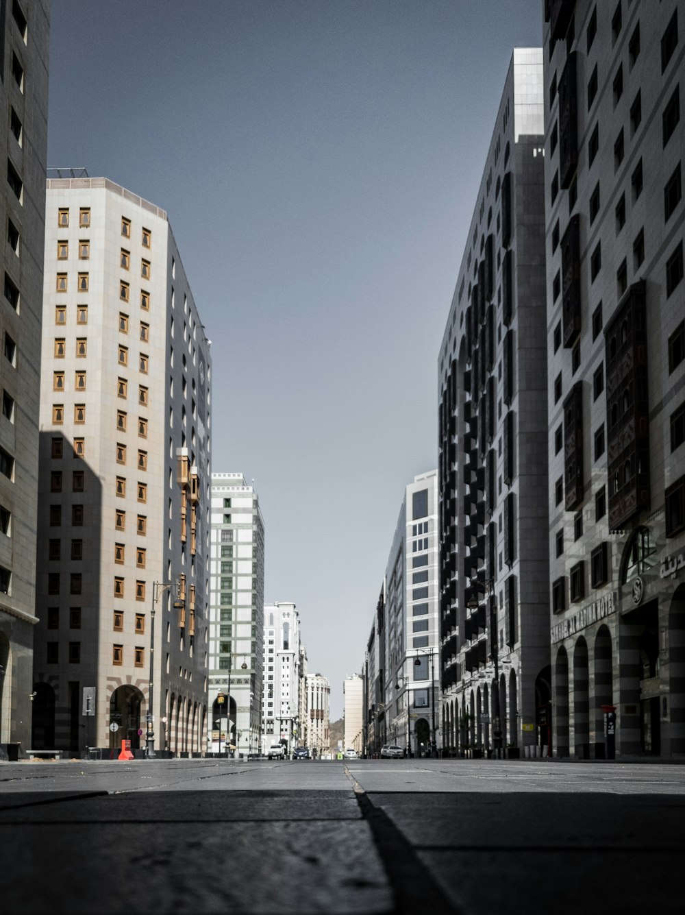 cars on road between high rise buildings during daytime