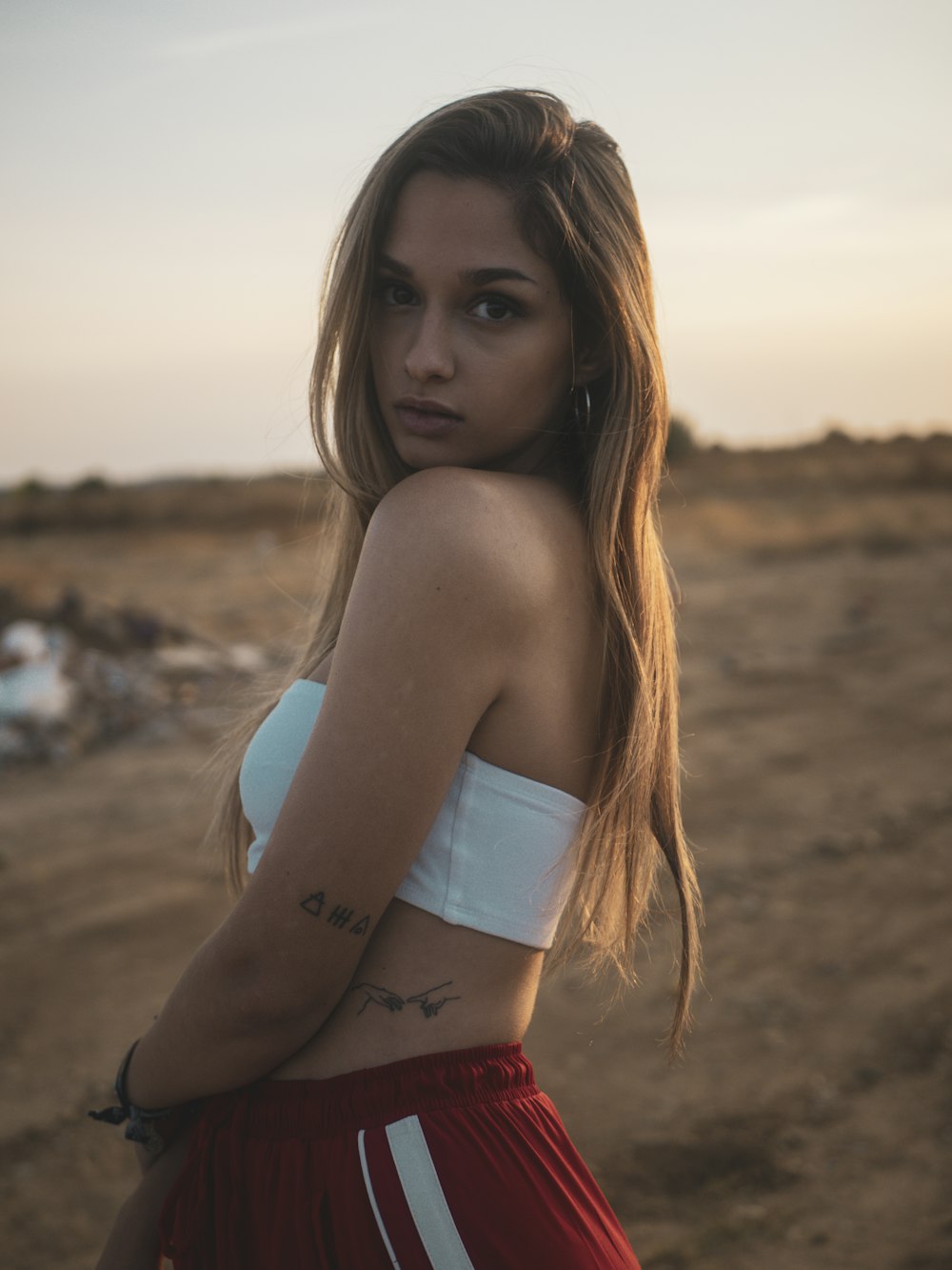 mulher na parte superior branca do biquíni e calcinha vermelha na praia durante o dia