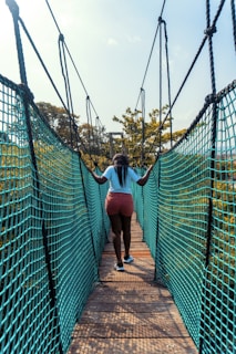 Group of teenagers crossing a rope bridge in a forest setting