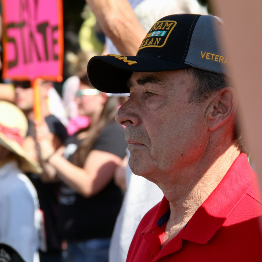 man in red polo shirt wearing black cap