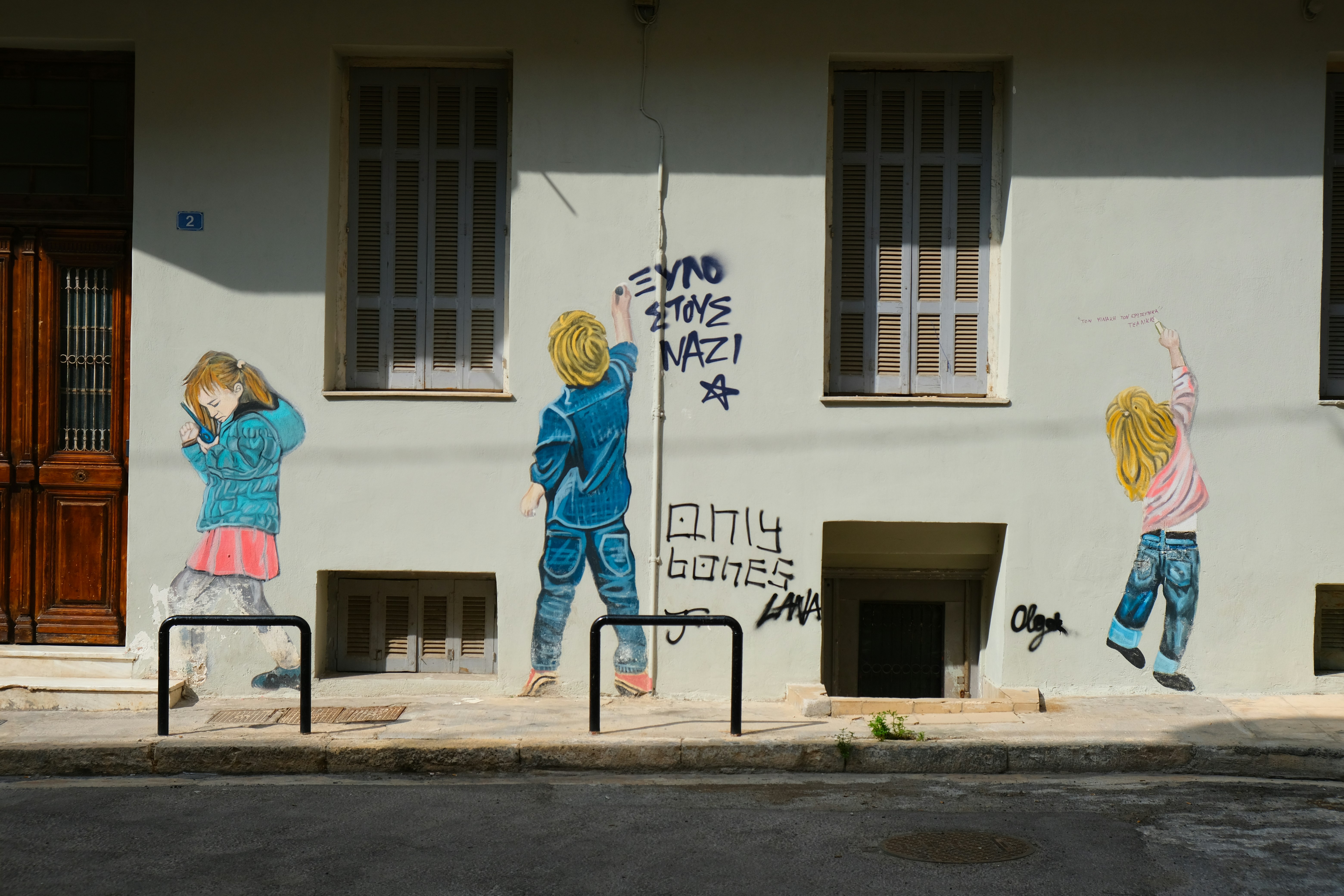 homme en chemise à manches longues bleue et blanche debout devant le bâtiment en béton blanc pendant