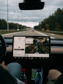 person holding white ipad inside car