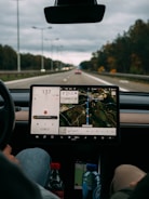 person holding white ipad inside car