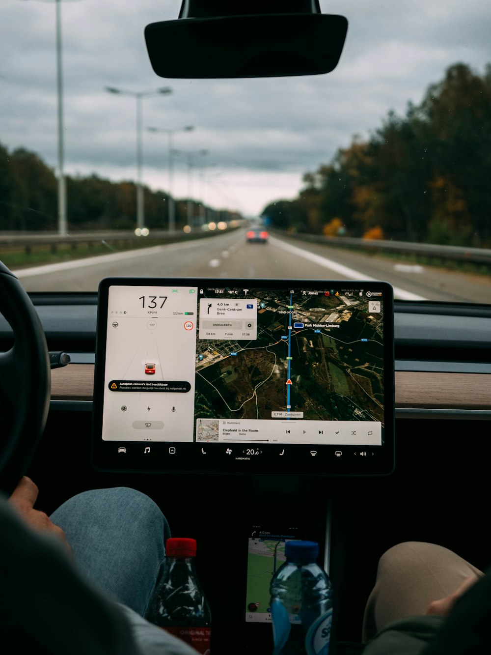 Personne tenant un iPad blanc à l’intérieur d’une voiture