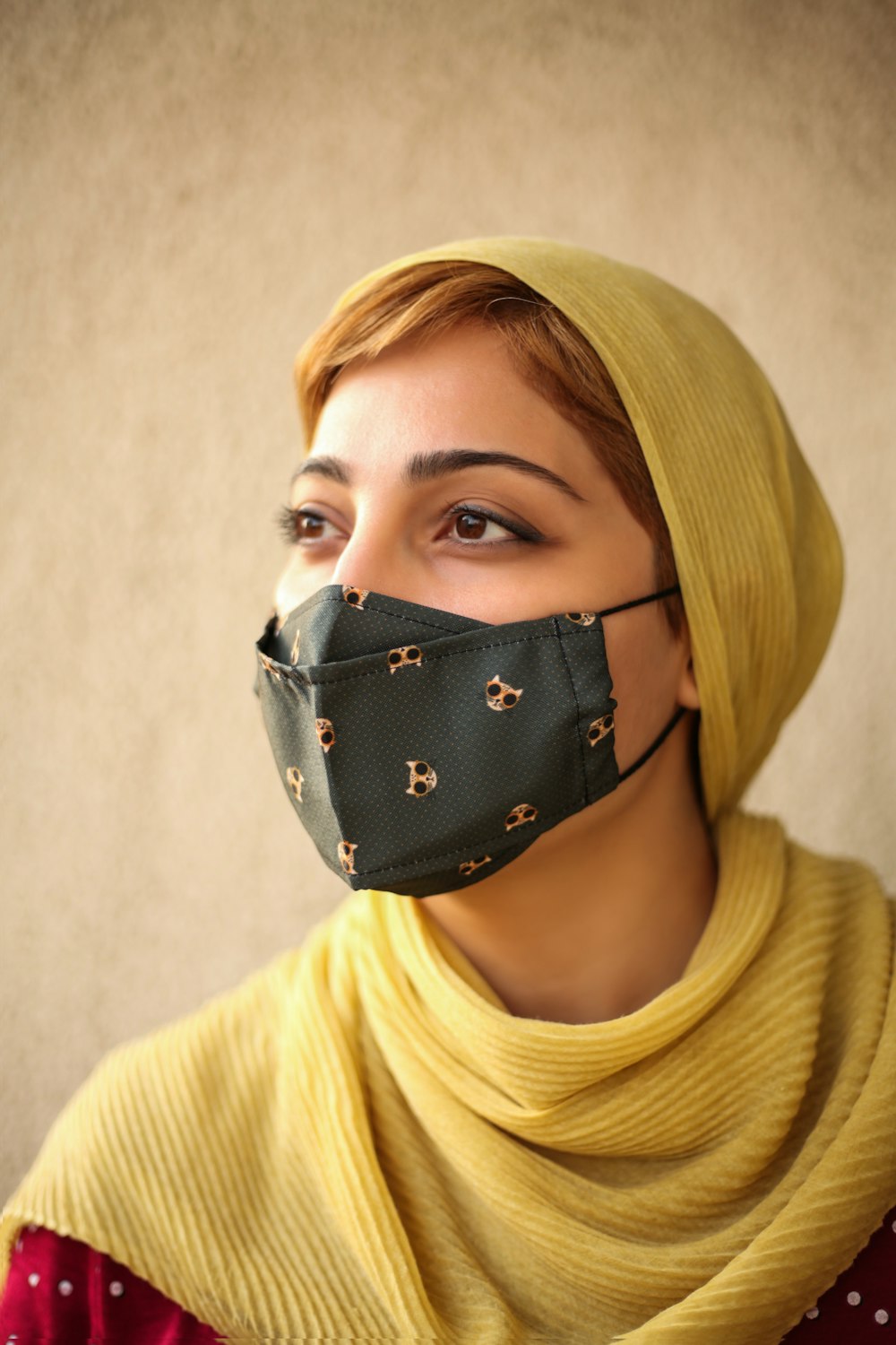woman in yellow turtleneck sweater wearing black and white mask