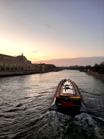 Luxury boat cruising along the Tagus River with Lisbon skyline at sunset.