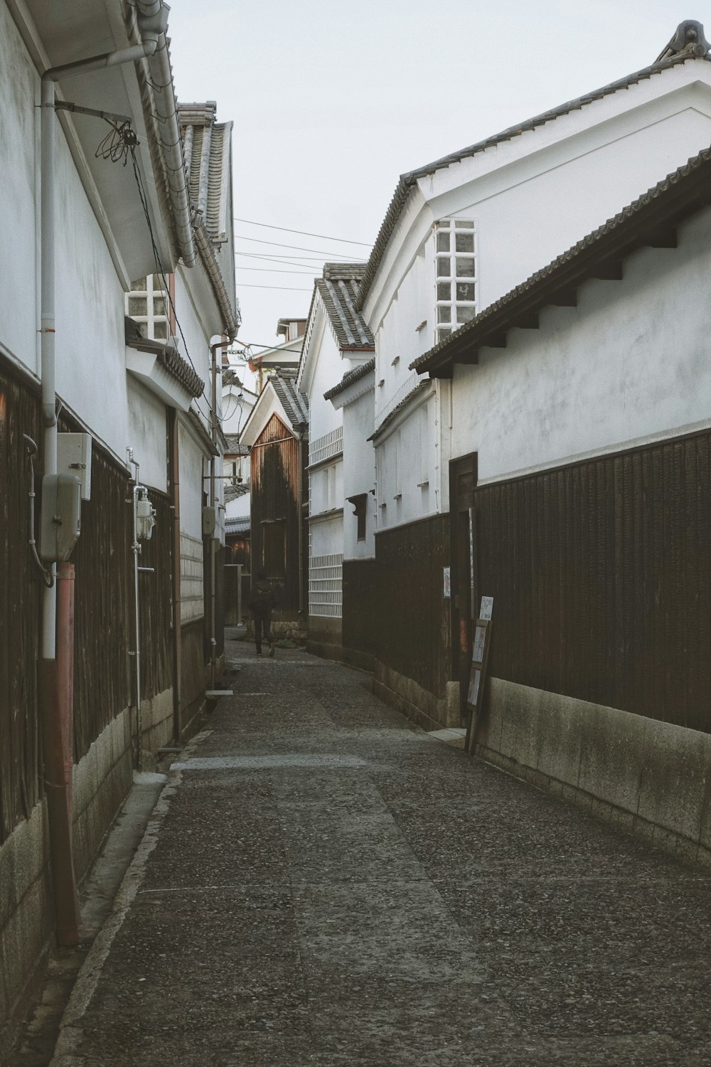 empty street between concrete houses during daytime