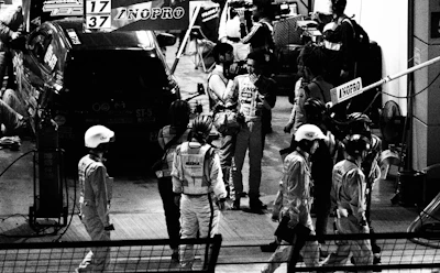 A close-up of a race car driver preparing in the pit area before a big race.