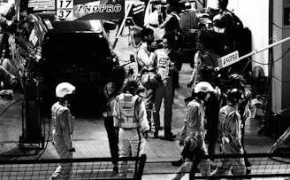 A team of drivers discussing strategies in a pit area.