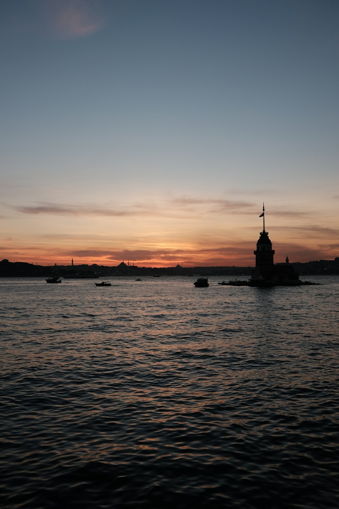 silhouette of boat on sea during sunset