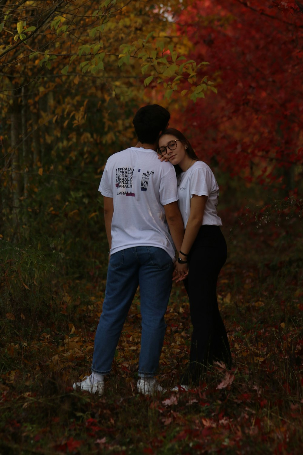 man in white crew neck t-shirt and blue denim jeans standing on green grass field