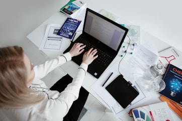 person in white long sleeve shirt using black laptop computer