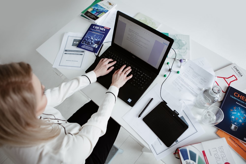 person in white long sleeve shirt using black laptop computer