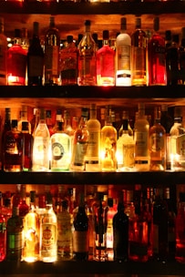 clear glass bottles on brown wooden shelf