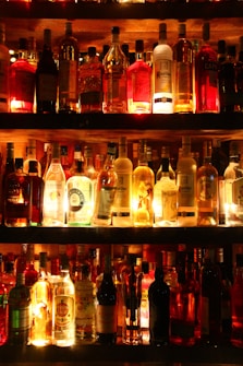 clear glass bottles on brown wooden shelf