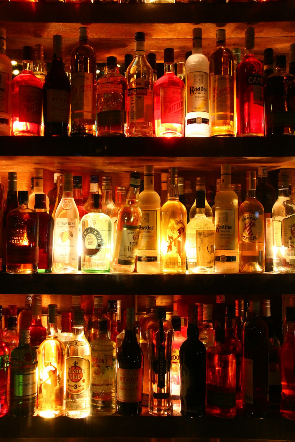 clear glass bottles on brown wooden shelf