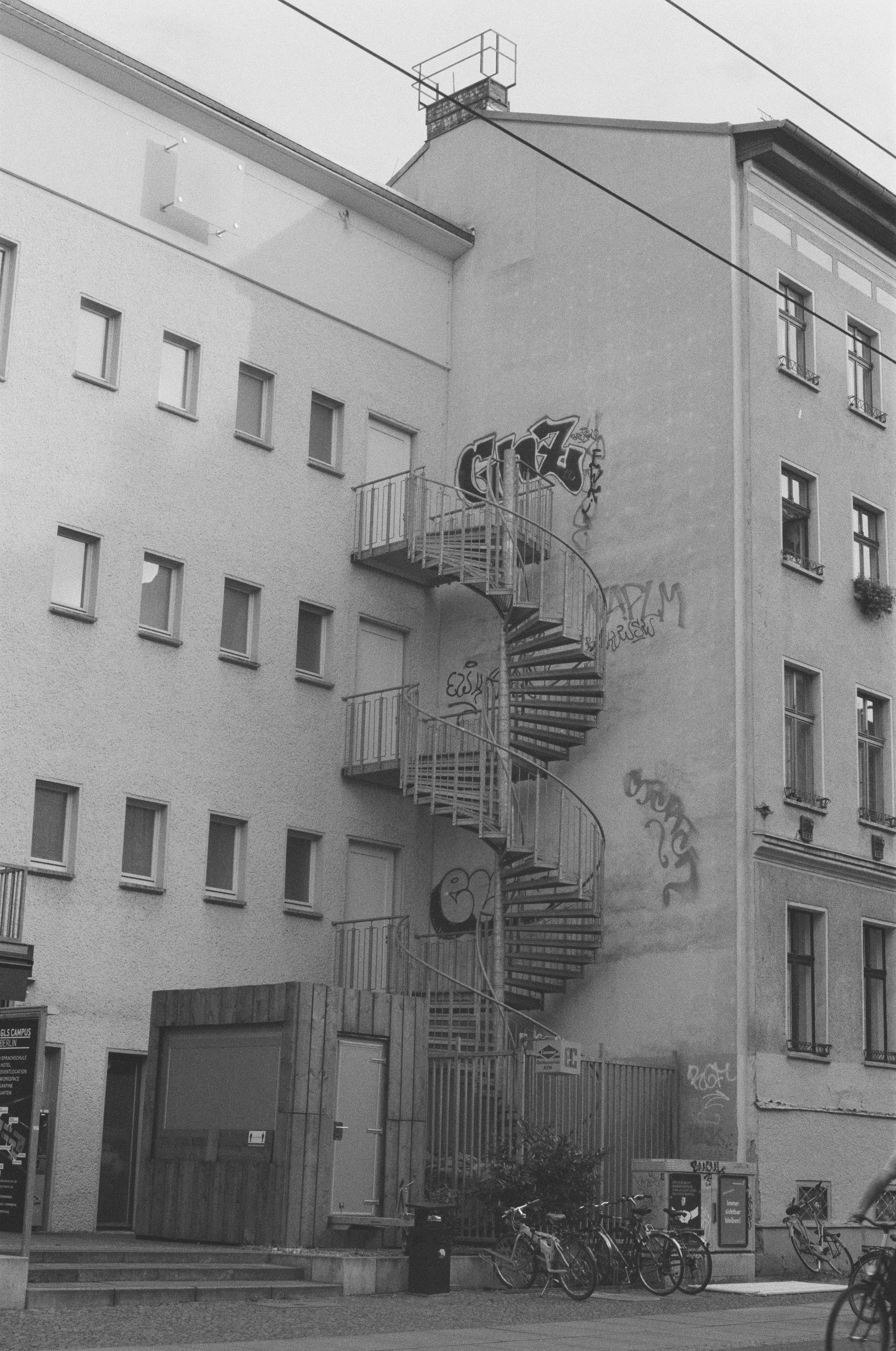 a black and white photo of a building with a spiral staircase
