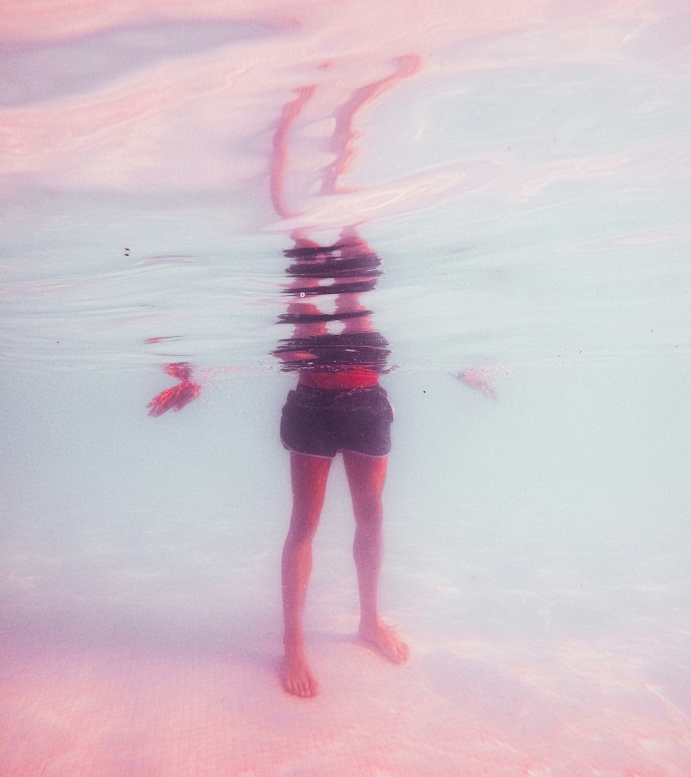 person in black shorts standing on water