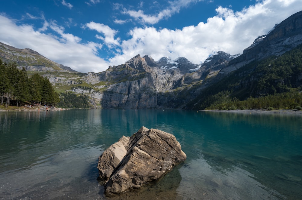 body of water near mountain under blue sky during daytime