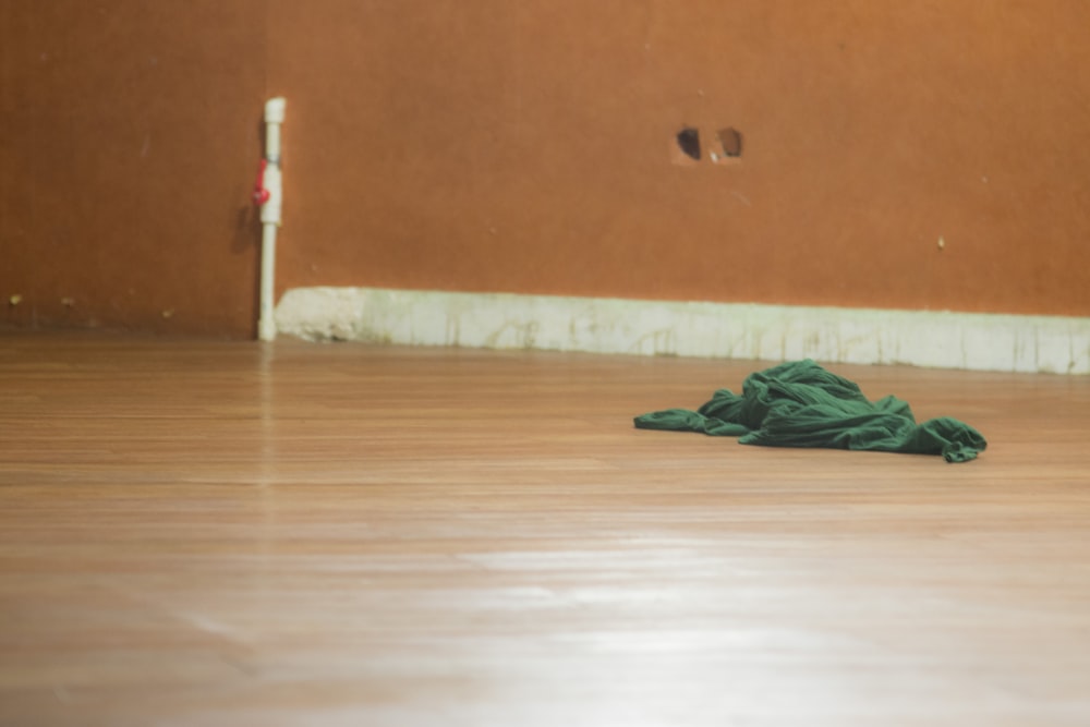 green textile on brown wooden floor